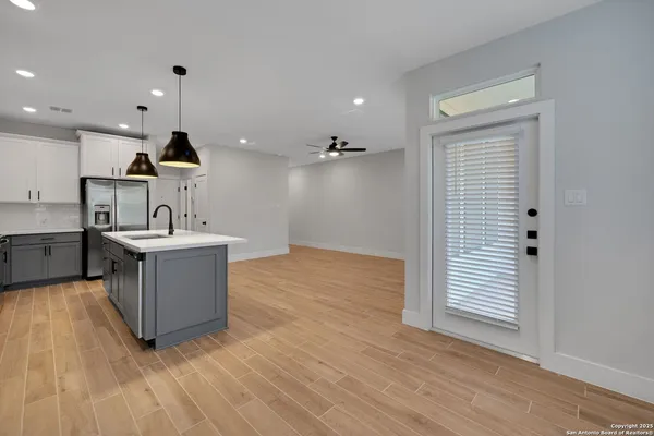 a kitchen with a sink and a dishwasher with wooden floor