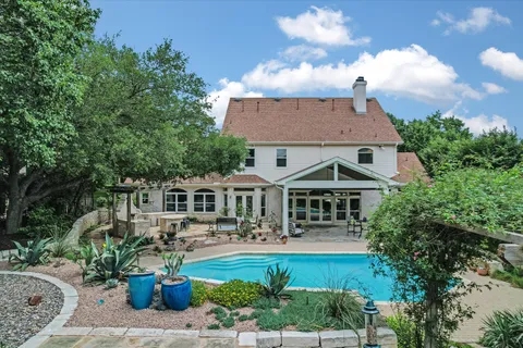 an aerial view of a house with a yard and trees all around