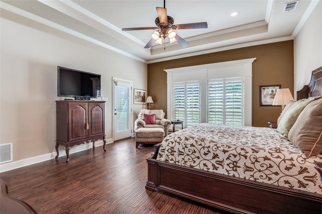 4041 Blackchamp Road Midlothian, TX 76065 - Photo 14 of 34 Another view of primary suite. Tray ceiling, fan, wide baseboards, views of backyard.