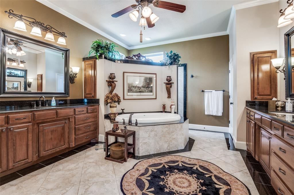 4041 Blackchamp Road Midlothian, TX 76065 - Photo 15 of 34 Ensuite primary bathroom. Shower behind garden tub, double vanities with ample storage! Tile flooring throughout, fan, crown molding! Just off this bathroom is a very spacious walk in closet with built ins!