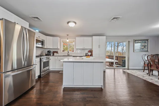 a kitchen with wooden floors and refrigerator