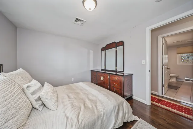 a bedroom with a bed and a mirror on dresser