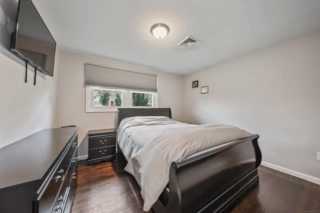 a bed sitting in a bedroom next to a window