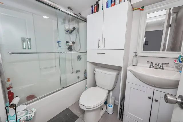 a bathroom with a sink a toilet and shower