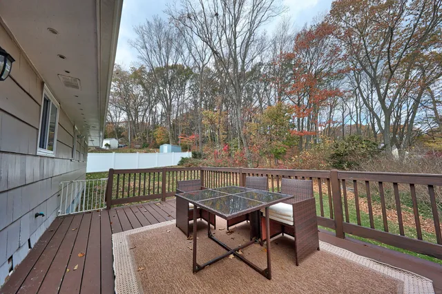 a view of a roof deck with wooden fence and trees
