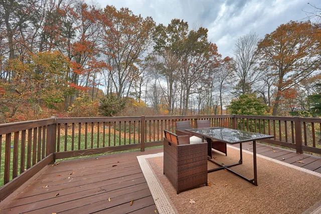 a balcony with wooden floor and outdoor seating