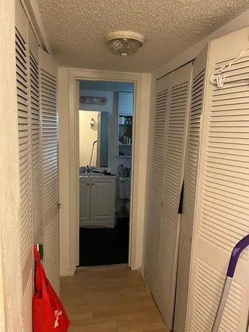 a view of hallway with bathroom and wooden floor