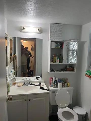 a bathroom with a toilet sink and mirror