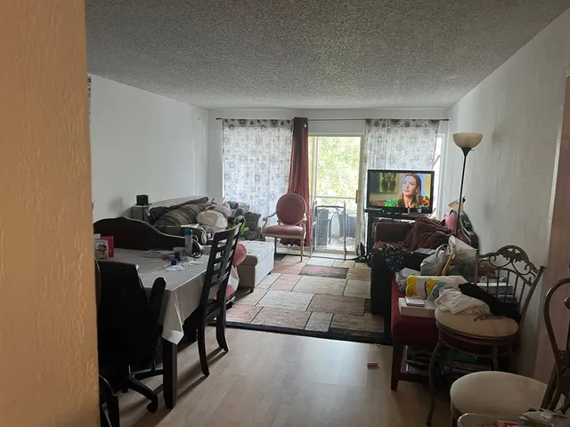 a living room with furniture a window and a flat screen tv
