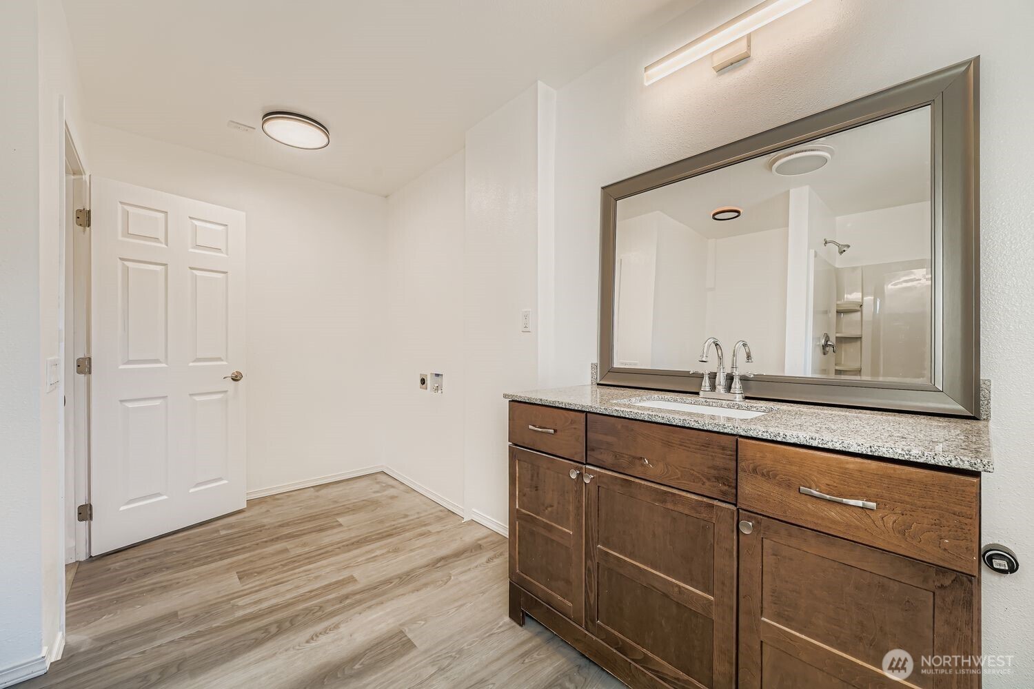 105 96th Street East Tacoma, WA 98445 - Photo 12 of 40 a bathroom with a granite countertop sink and a mirror