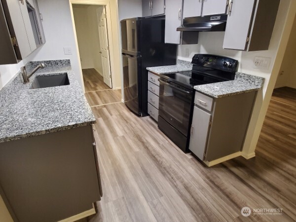 105 96th Street East Tacoma, WA 98445 - Photo 35 of 40 a kitchen with stainless steel appliances granite countertop a sink stove and refrigerator