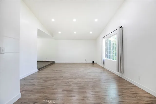 a view of an empty room with a fireplace and a window