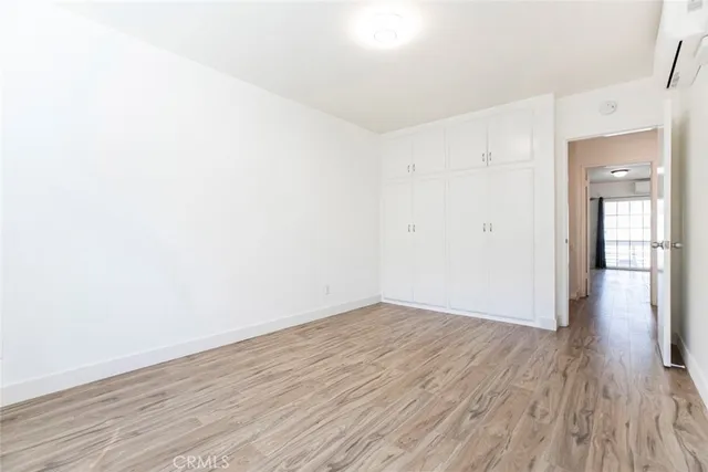 an empty room with a fireplace and chandelier fan
