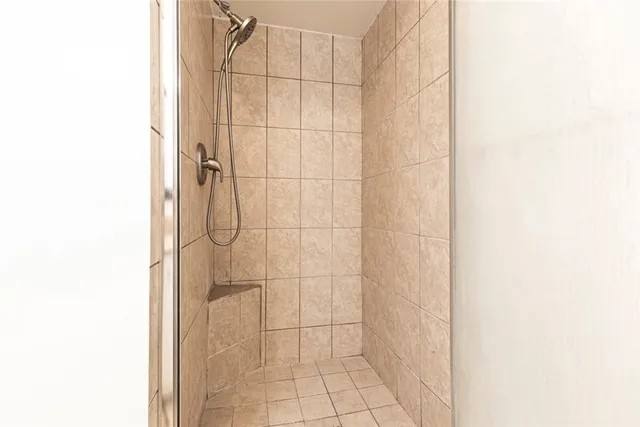 a view of an empty room with wooden floor fireplace and a window