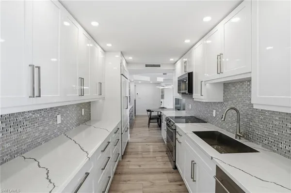 a kitchen with a sink stove top oven and cabinets