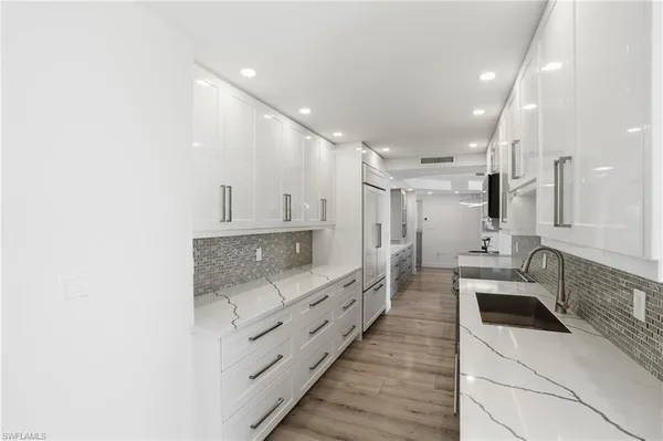 a large white kitchen with stainless steel appliances