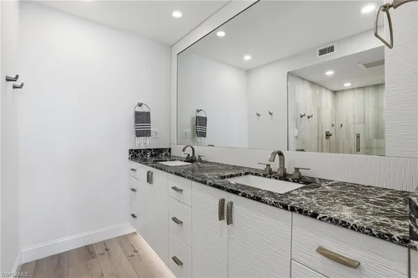 a bathroom with a granite countertop sink and a mirror