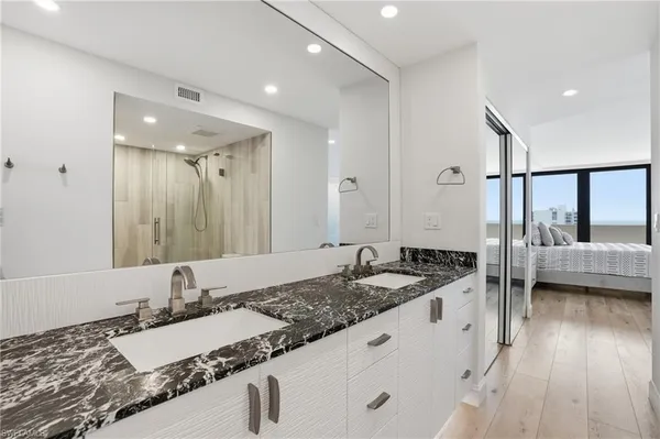 a bathroom with a granite countertop sink and a large mirror