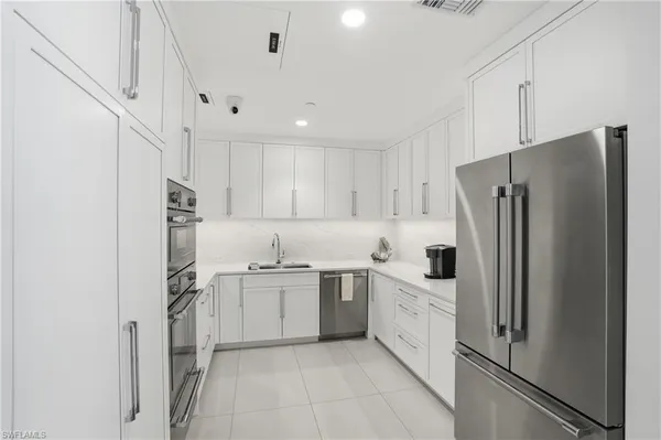 a kitchen with stainless steel appliances a refrigerator sink and microwave