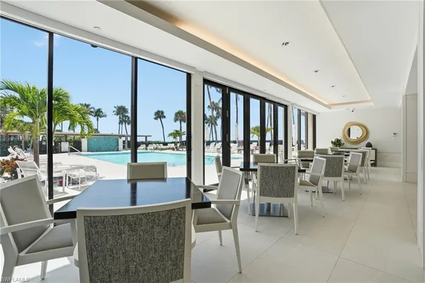 a dining room with furniture and a floor to ceiling window