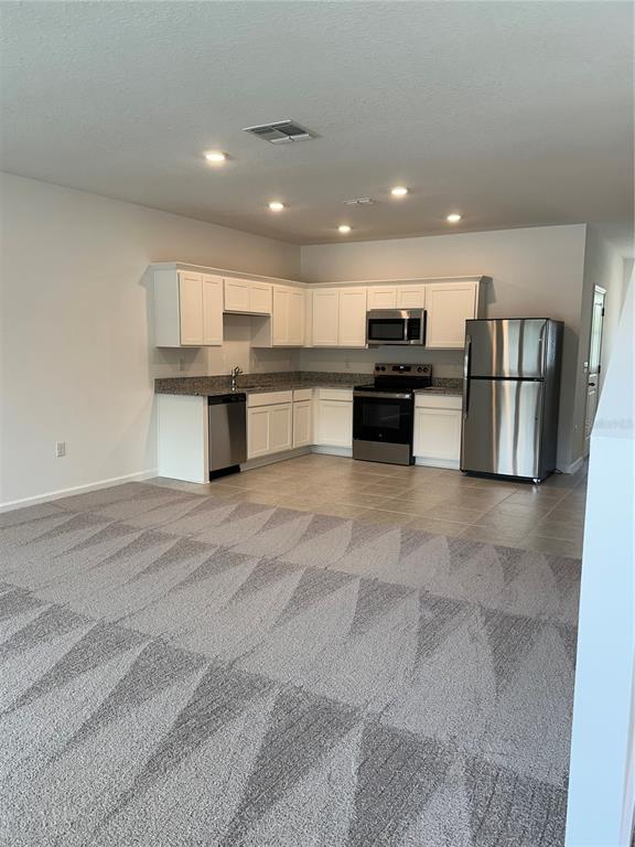 374 Cadberry Place St. Cloud, FL 34771 - Photo 6 of 11 a kitchen with a refrigerator and a stove top oven