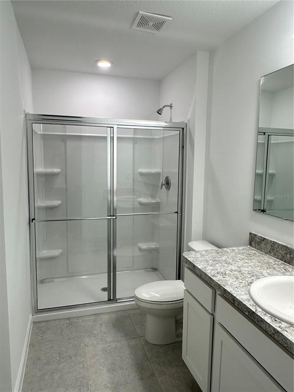 374 Cadberry Place St. Cloud, FL 34771 - Photo 10 of 11 a bathroom with a granite countertop sink a toilet and shower