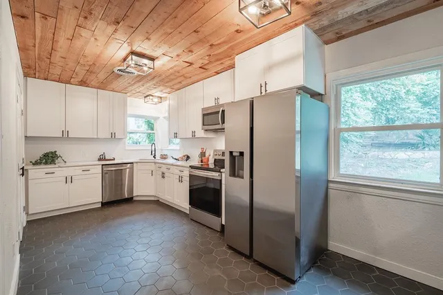 a kitchen with a white refrigerator sink and cabinets