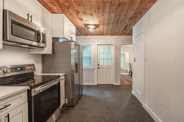 a kitchen with stainless steel appliances a stove microwave and refrigerator