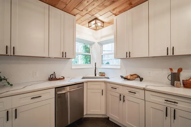 a kitchen with cabinets appliances a sink and a window