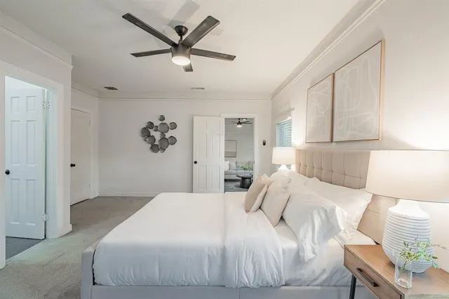 a bedroom with a large bed and a chandelier