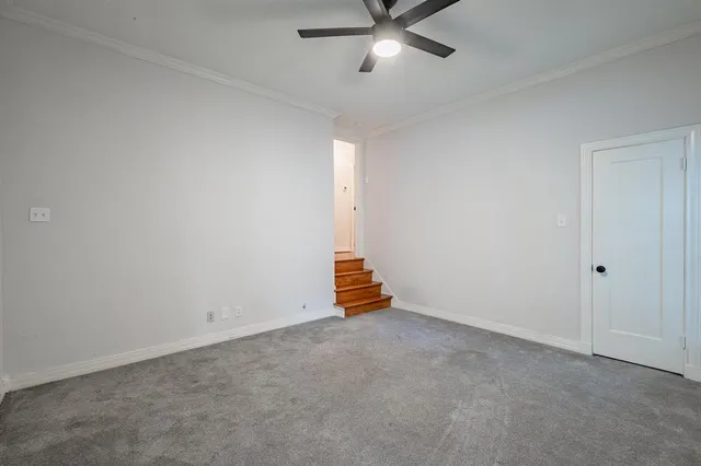 an empty room with a ceiling fan and window