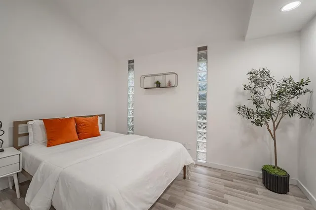 a bedroom with a bed and a potted plant