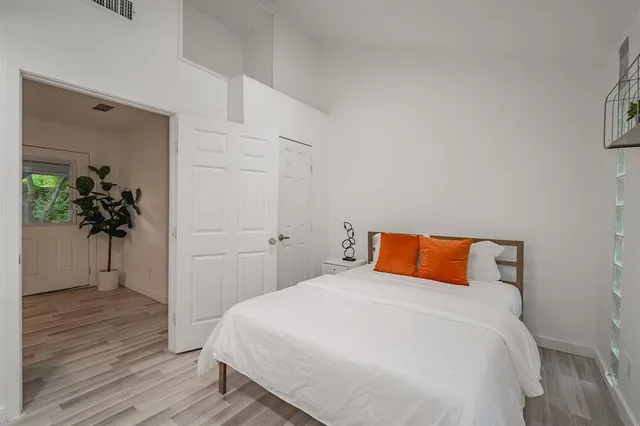 a bedroom with a bed and a potted plant