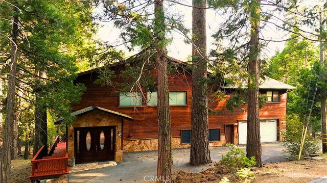 a front view of a house with a tree