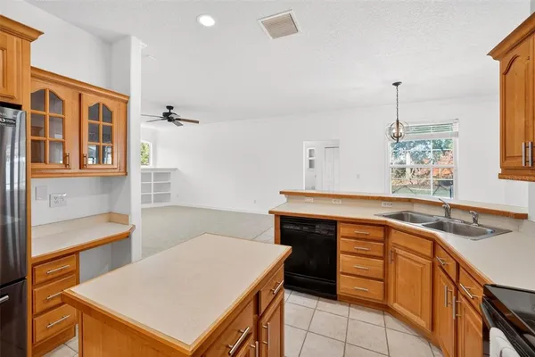 an empty room with ceiling fan and window