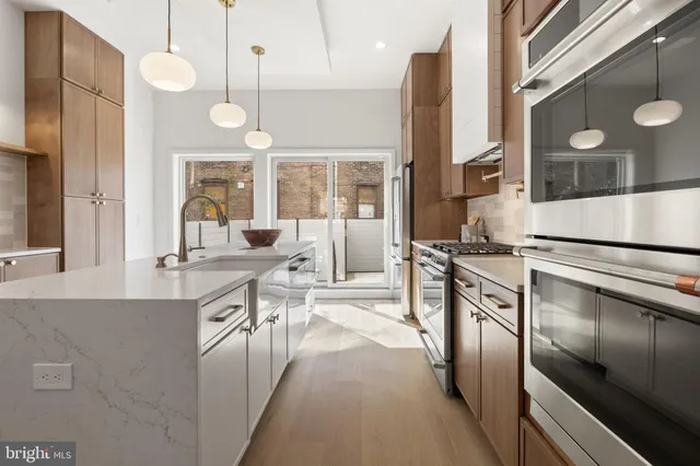 a kitchen with stainless steel appliances granite countertop a sink and a refrigerator