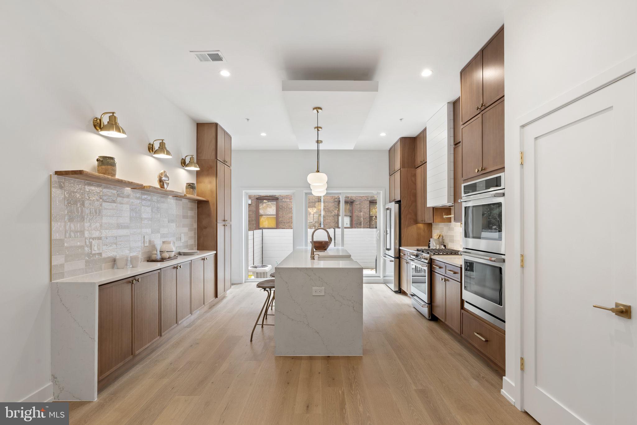 503 Winton Street Philadelphia, PA 19148 - Photo 17 of 65 a large kitchen with stainless steel appliances lots of counter space and wooden floor