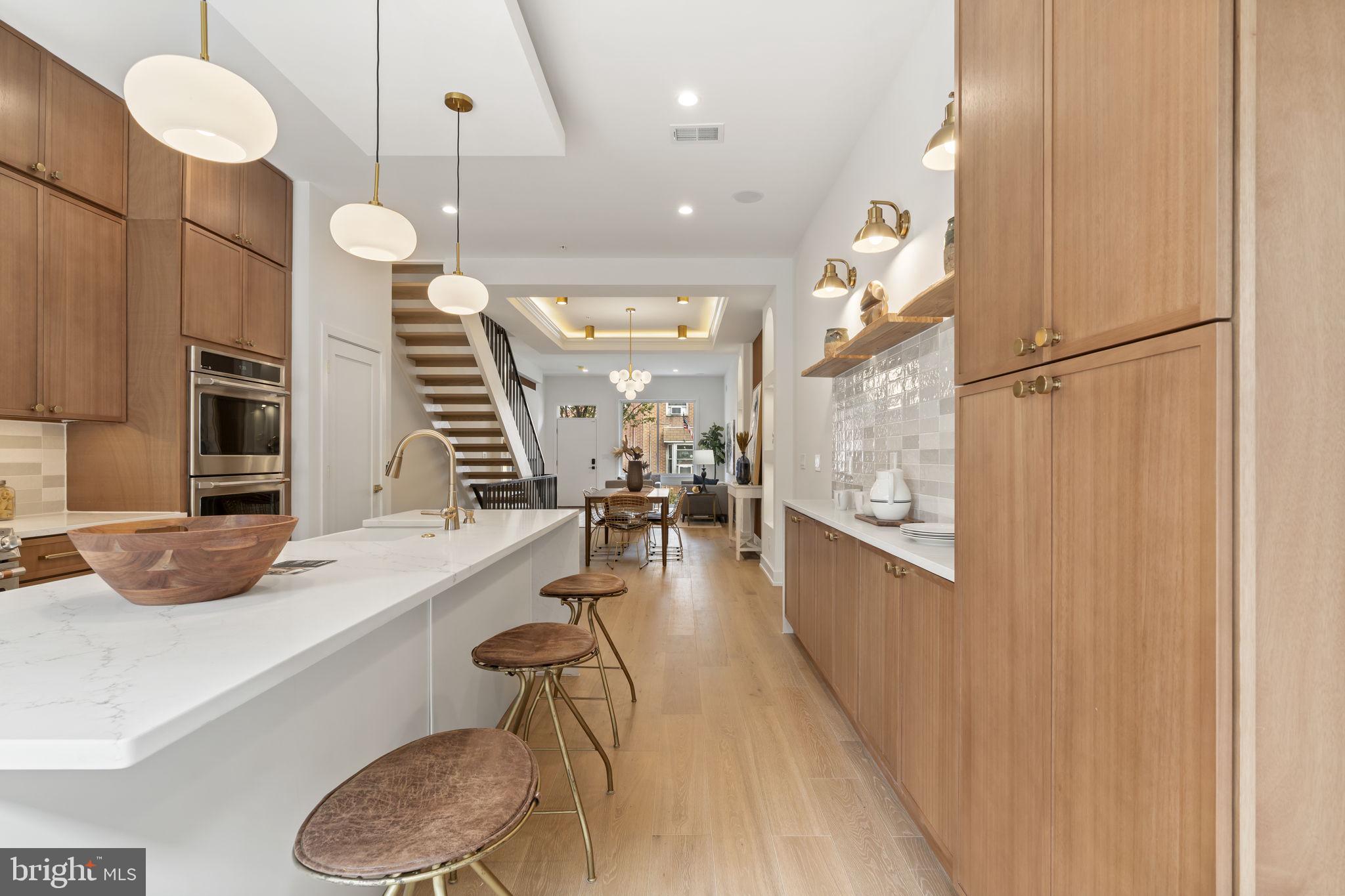 503 Winton Street Philadelphia, PA 19148 - Photo 20 of 65 a kitchen with stainless steel appliances kitchen island granite countertop a refrigerator a oven a sink and a dining table with wooden floor