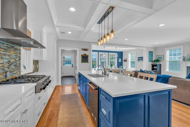 a large kitchen with kitchen island a stove a sink a dining table and chairs