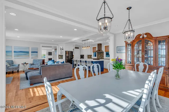 a living room with furniture a dining table and a chandelier