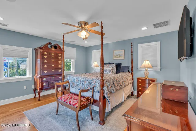 a bedroom with bed and wooden floor