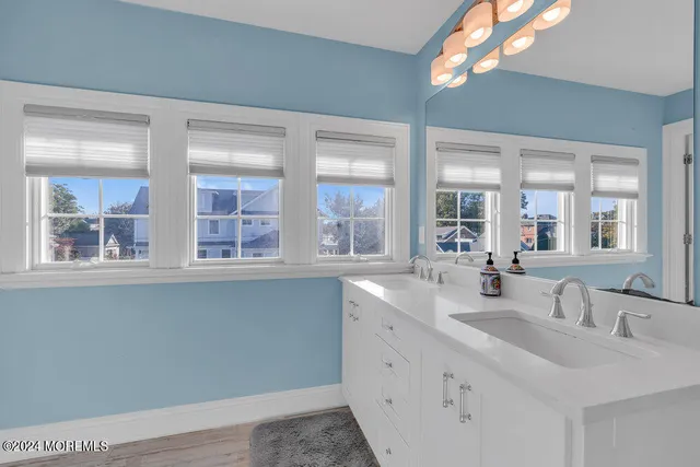 a bathroom with double vanity and a large mirror