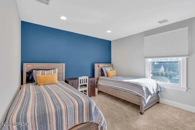 a bedroom with two beds and window