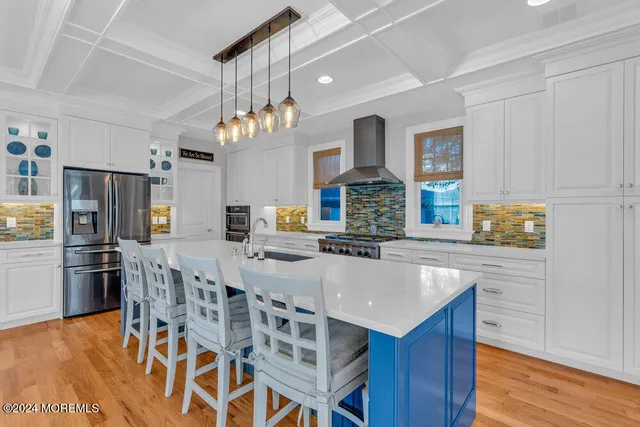 a large kitchen with kitchen island a large counter space a sink appliances and cabinets