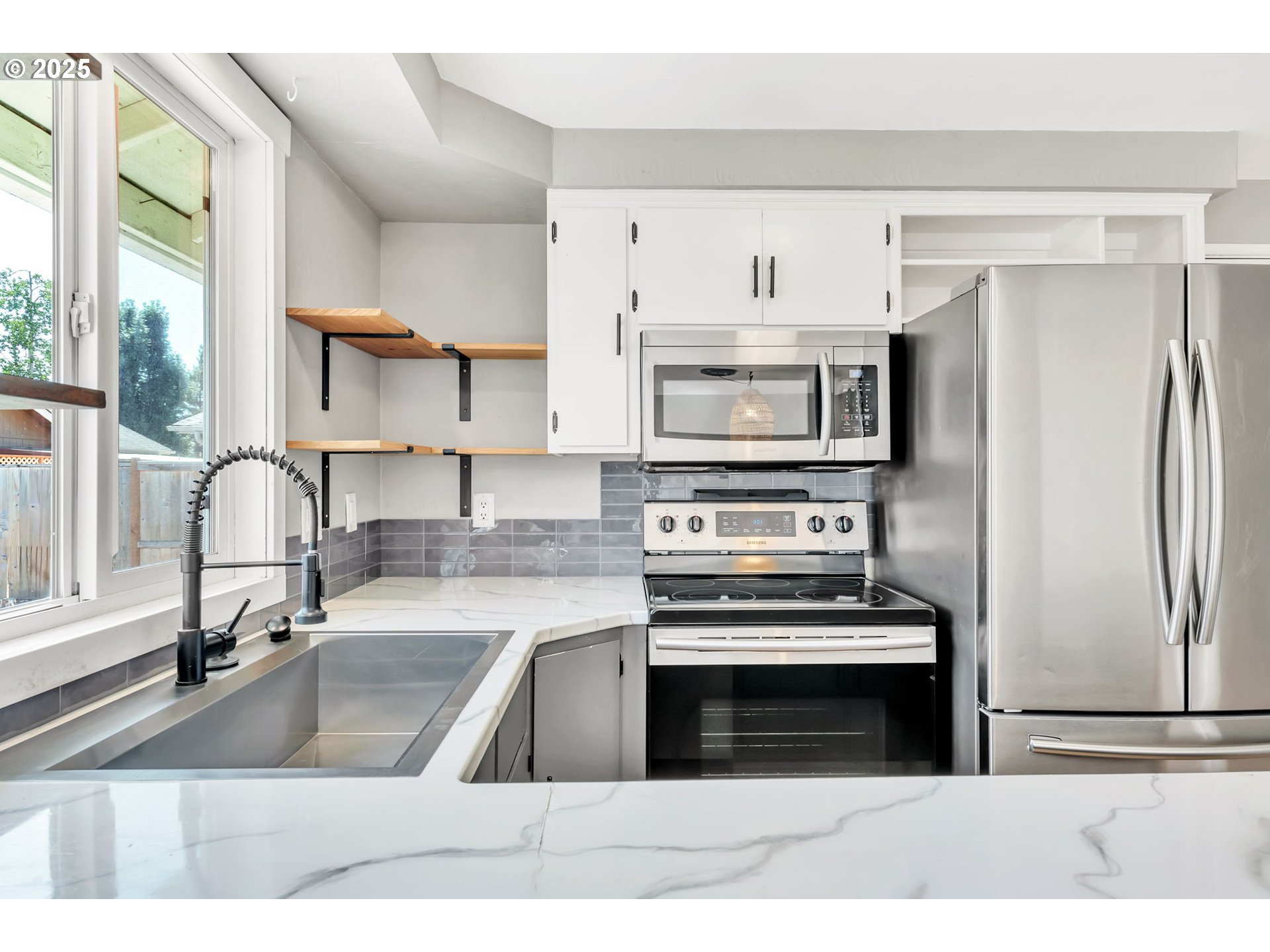 6781 F Street Springfield, OR 97478 - Photo 11 of 48 a kitchen with granite countertop a stove a sink and a refrigerator