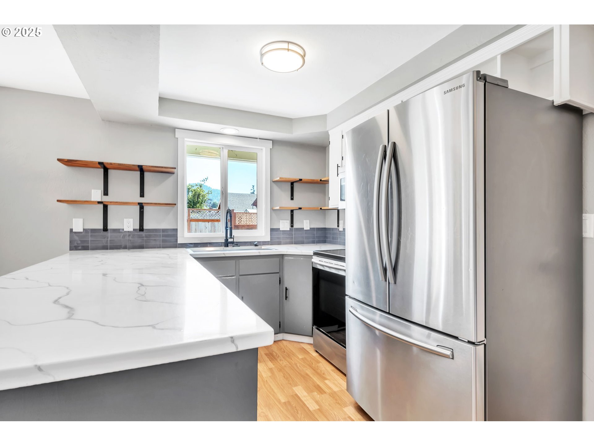 6781 F Street Springfield, OR 97478 - Photo 9 of 48 a kitchen with stainless steel appliances a refrigerator sink and cabinets