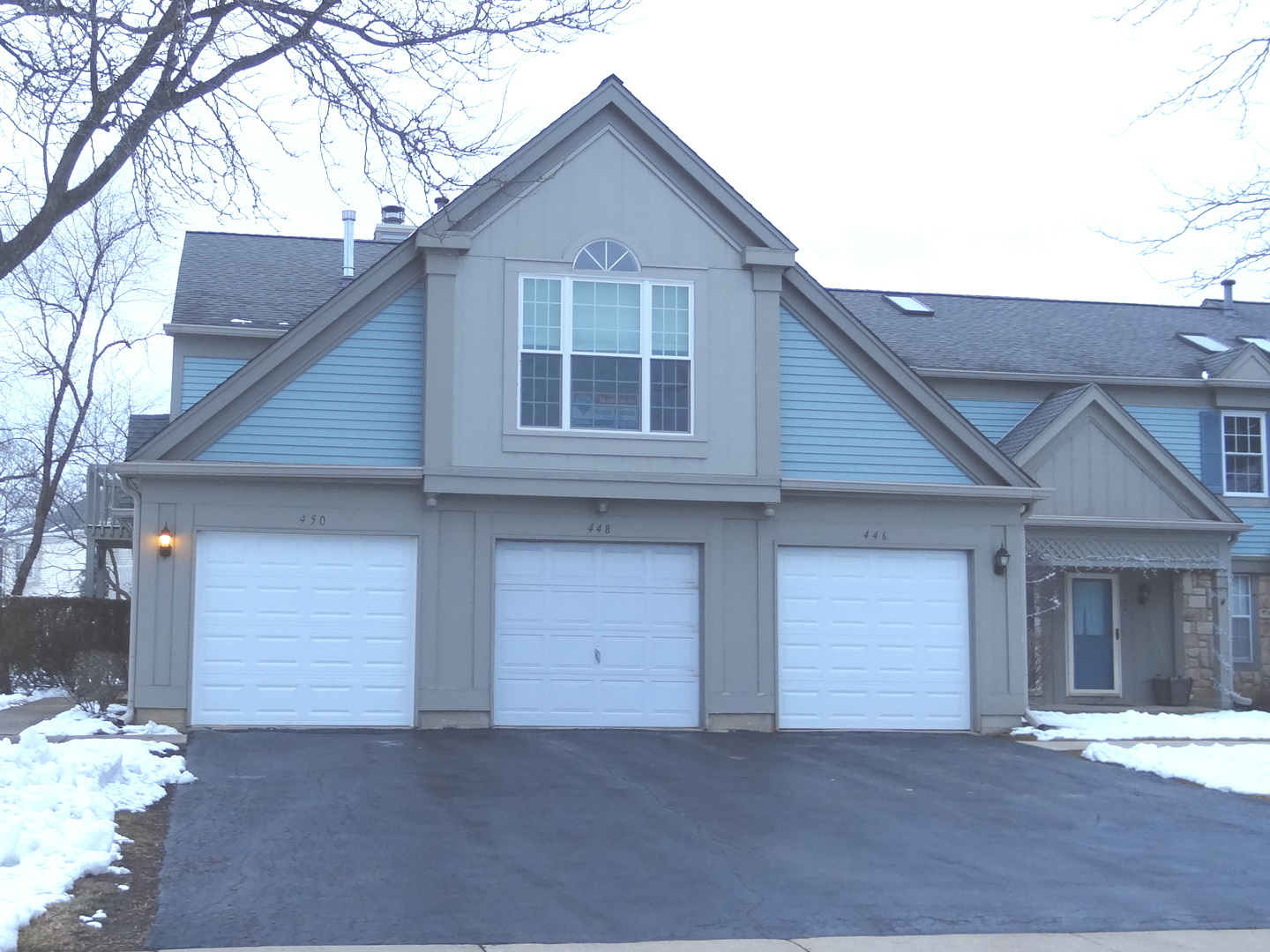 450 Bridle Trail, Unit 450 Wheeling, IL 60090 - Photo 1 of 15 a front view of a house with a yard and garage