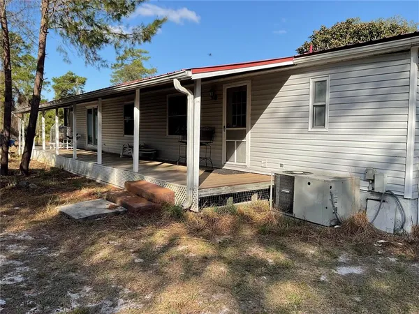 a view of a house with backyard and chairs