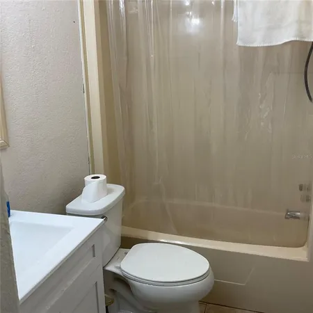 a white toilet sitting next to a white tub