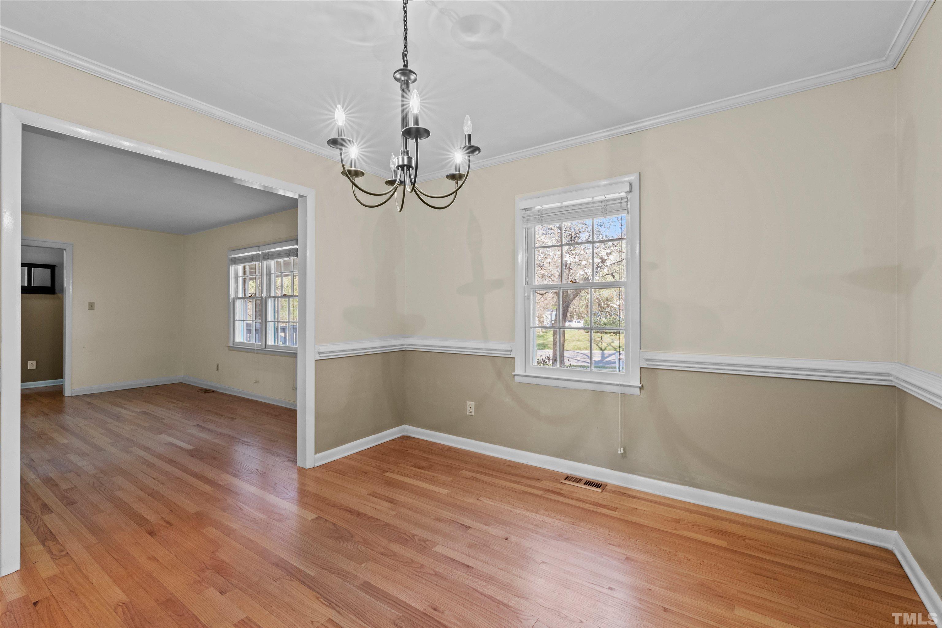6000 Buffaloe Road Raleigh, NC 27616 - Photo 34 of 36 an empty room with wooden floor chandelier and windows
